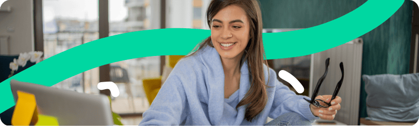 Une femme souriante qui regarde un ordinateur 